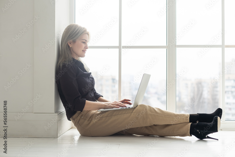 Image of young pleased happy cheerful cute beautiful business woman indoors in office using laptop computer Image of young pleased happy cheerful cute beautiful business woman indoors in office using laptop computer