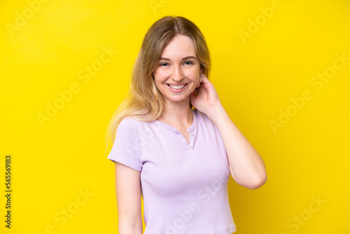 Blonde English young girl isolated on yellow background laughing