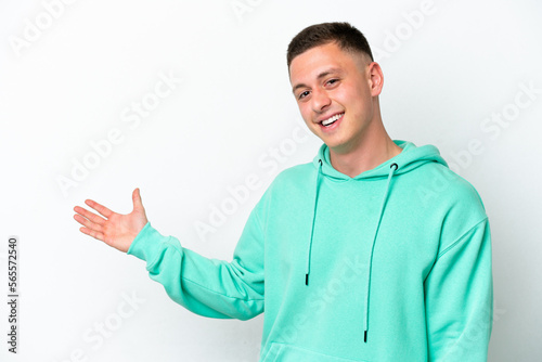 Young brazilian man isolated on white background extending hands to the side for inviting to come © luismolinero