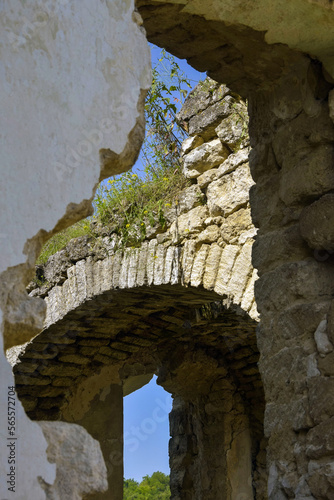 Ruins of ancient building against blue sky. Collapsed ceiling. Masonry, room with arched vaults in christian church. Grass grows on walls. Rashkov, Moldova. Copy space. Selective focus. photo