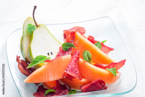 melon cantaloupe and pear with  proscutto and mint leaves photo