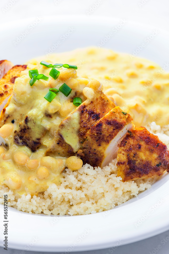 chicken breast served with creamy curry chickpea sauce and couscous