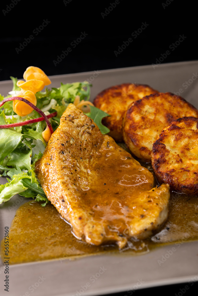 poultry meat with sauce served with hash browns and salad poultry meat with sauce served with hash browns and salad