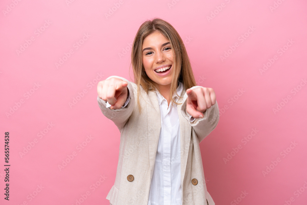Young caucasian woman isolated on pink bakcground surprised and pointing front Young caucasian woman isolated on pink bakcground surprised and pointing front