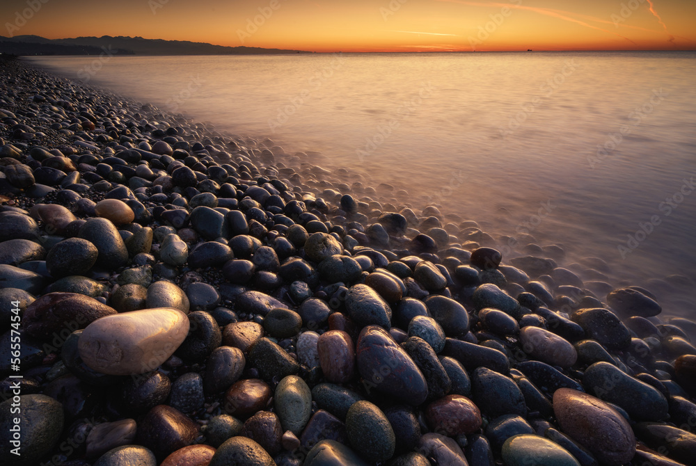 Obraz premium Sunset on the sea stones shore