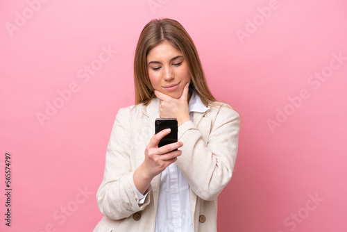 Young caucasian woman isolated on pink bakcground thinking and sending a message