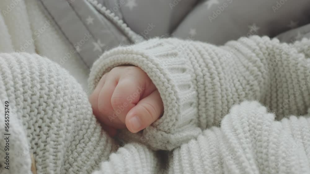 Close-up view of the palm of a sleeping baby lying in the cradle in winter