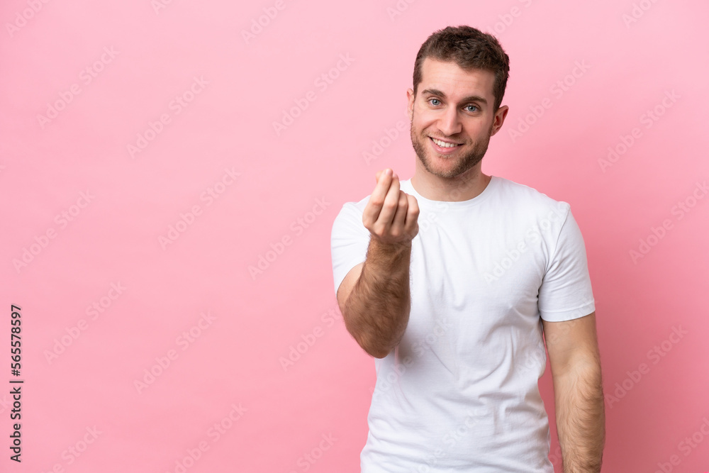 Young caucasian man isolated on pink background making money gesture Young caucasian man isolated on pink background making money gesture