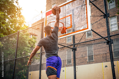 Athletic african american basketball player training on a court in New York - Sportive man playing basket outdoors