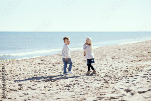 Obraz na płótnie Two toddlers on the beach smiling with mutual understanding w salonie