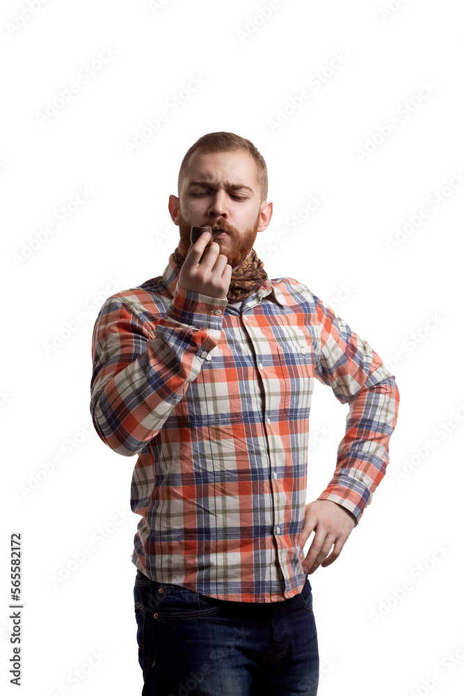Handsome bearded redhead man in checked shirt smoking pipe while isolated on white background Handsome bearded redhead man in checked shirt smoking pipe while isolated on white background