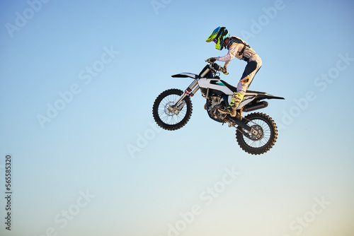 Motorbike, jump and person on blue sky mockup for training, competition and challenge with safety gear. Professional cycling, motorbike and adventure with speed, sports and danger on mock up space