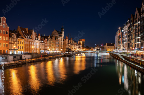 Night image of the river and the buildings of the city of Gdansk (Poland) illuminated, capturing the reflection of the water.