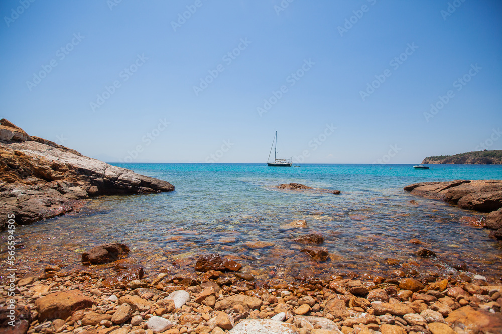 Breathtaking view of clear turquoise color of sea, seascape with yachts at bay. Clear blue sky on a sunny day. Summer travel holidays concept. Panoramic view. Greece shoreline.