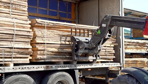 Forklift Uploads Heavy Truck With Wood Block Stacks At Sawmill. Oak Boards