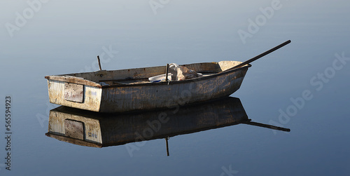 verlassenes Ruderboot spiegelt sich im Wasser photo