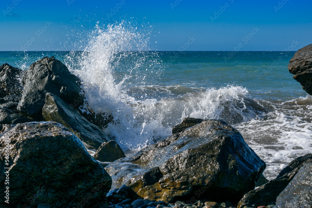 Splashing big wave crashing into the rocks in the rough wild water of the Atlantic Ocean