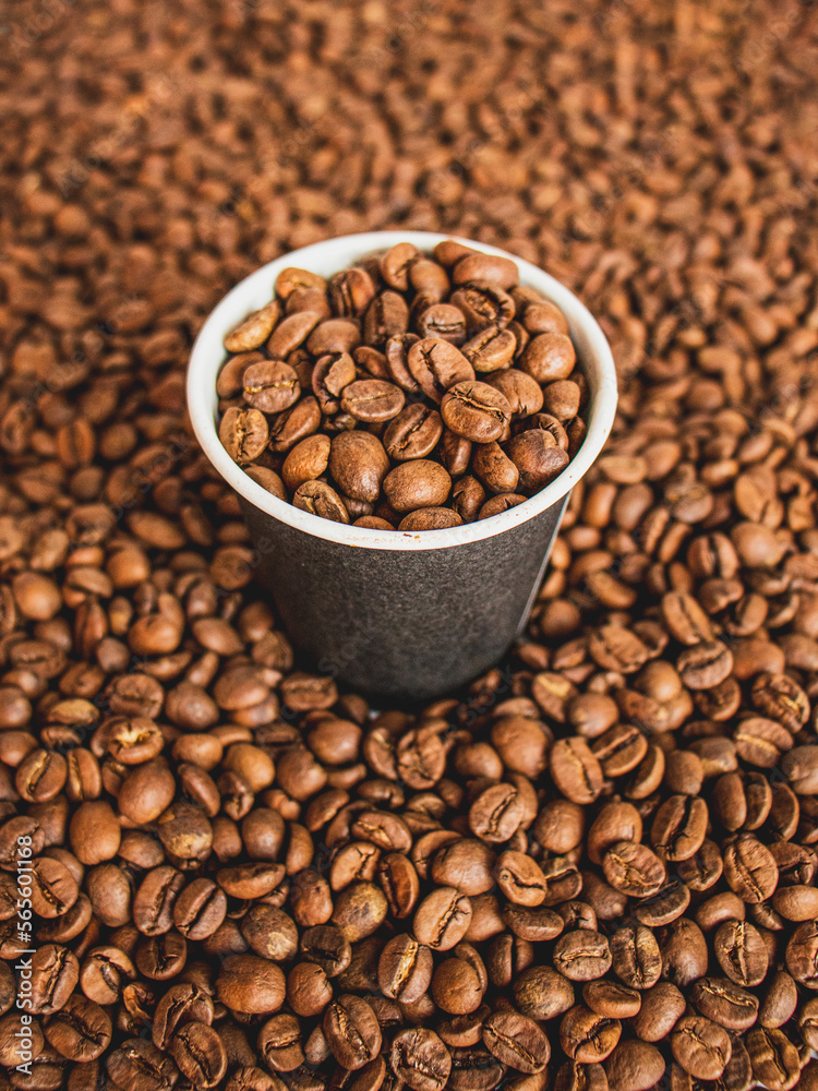 coffee beans in a paper cup on the background of coffee beans, epresso concept close up