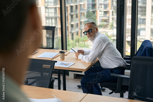 Serious businessman sitting at office with smartphone in hands © Svitlana