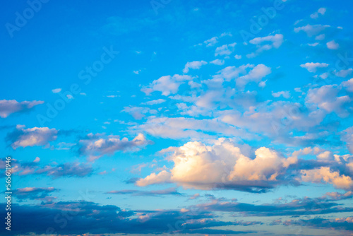 Sky with cumulus clouds and golden sunlight, nature abstract background.