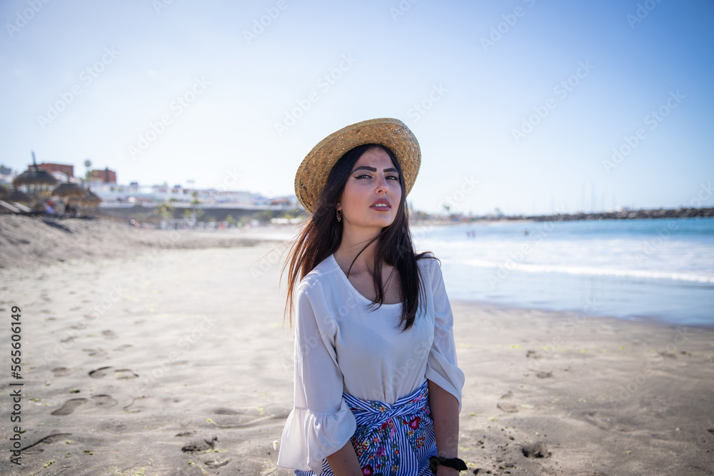 An attractive Mediterranean woman at the beach enjoys her holidays.