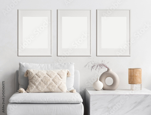 Blank picture frame mockup on white wall. Modern living room design. View of modern scandinavian style interior with sofa. Three vertical templates for artwork, painting, photo or poster