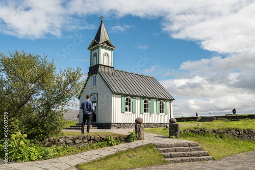 Caucasian tourist in front of Thingvallakirkja church in Iceland photo