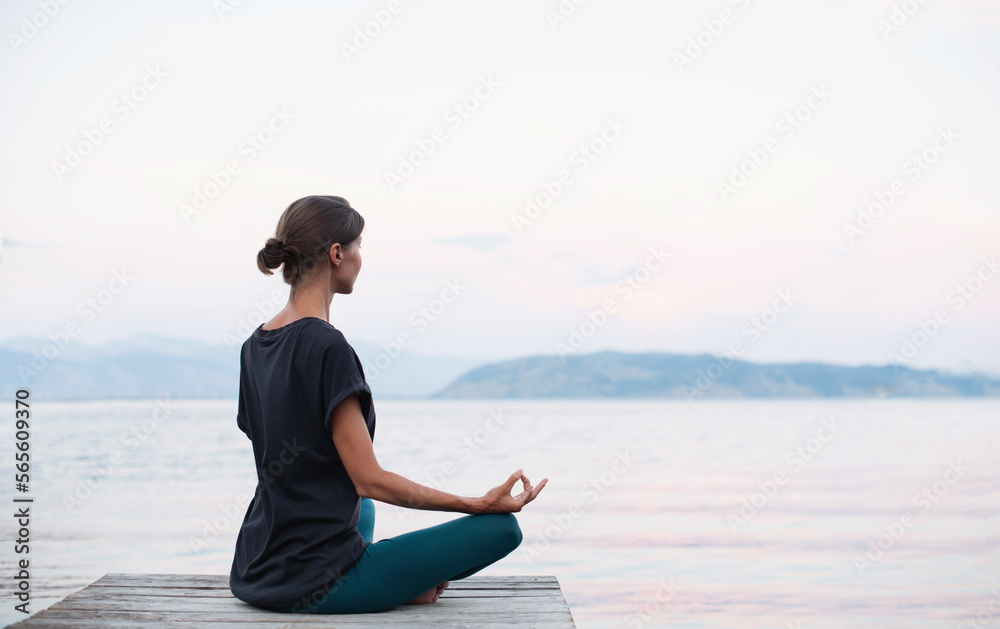 Beautiful woman practicing yoga near the sea, Young girl meditate at sunset, Harmony, meditation, healthy lifestyle and travel concept