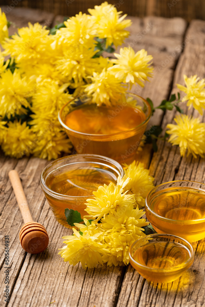 Honey, dipper and yellow flowers on an aged wooden background. Honey, dipper and yellow flowers on an aged wooden background.