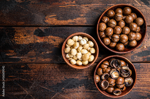 Unshelled Macadamia nuts ready to eat. Wooden background. Top view. Copy space