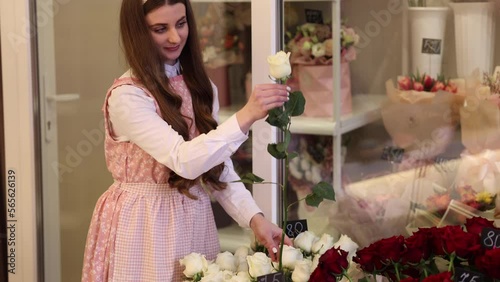 Woman make spring bouquet. Female florist wrapping beautiful bouquet of spring flowers in pack paper on the table. Beautiful flower composition