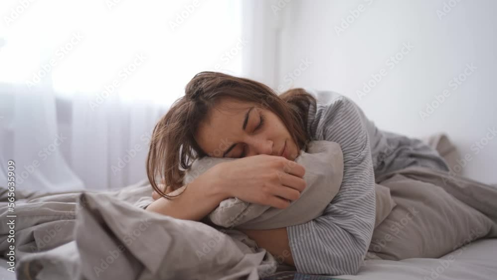 young woman lies alone on bed at home, cold and sick. illness, cold, virus, doctor's call at home, consultation with a doctor by phone young woman lies alone on bed at home, cold and sick. illness, cold, virus, doctor's call at home, consultation with a doctor by phone