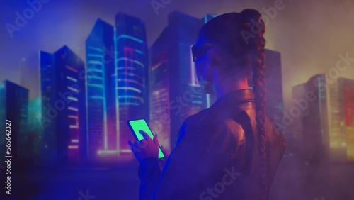 Portrait of cyberpunk girl with a smartphone. Beautiful young woman on the background of city scyscrapers. Futuristic concept. photo