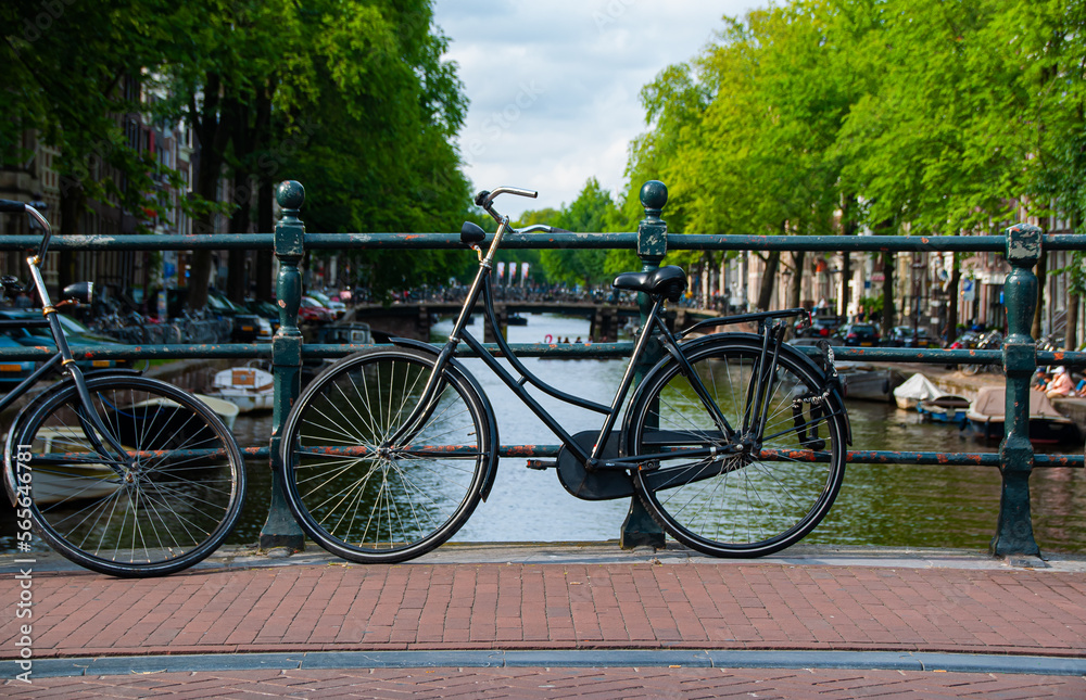 A black bicycle over a canal in Amsterdam during the Summer
