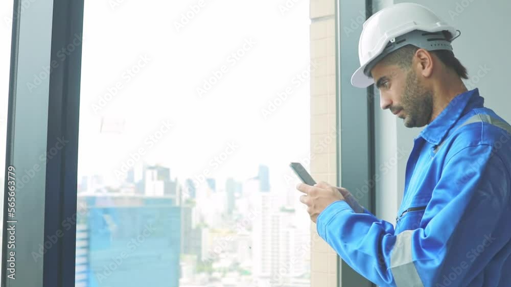 Portrait male architect engineer, construction supervisor talking on smartphone typing messages via application group of workers to perform tasks and command via message for convenience during work. Portrait male architect engineer, construction supervisor talking on smartphone typing messages via application group of workers to perform tasks and command via message for convenience during work.