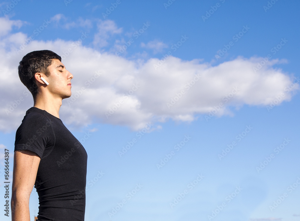 Strong yooung man relaxing breathing fresh air on a roof in a cloudy day listening to music Strong yooung man relaxing breathing fresh air on a roof in a cloudy day listening to music