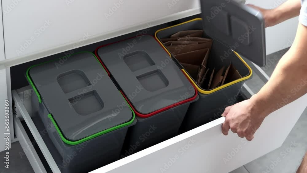 Colorful bins for sorting of plastic, paper garbage and organic waste at home. Modern kitchen with a system for sorting waste. Waste Separation Concept. Zero waste. Eco-friendly. 4K footage
