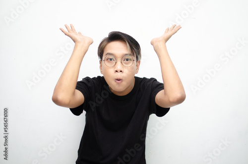 A cheerful, ecstatic Asian man wears a casual black t-shirt, pointing to copy space and presenting and displaying goods. billboard model advertisment concept. A man with a wow expression displaying so