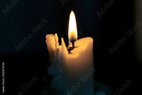 Burning candle in a dark room. Bright candle flame in the darkness