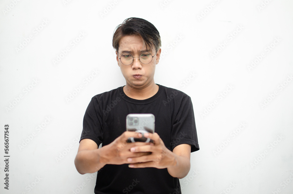 Young Asian man with peek-a-boo hair, sad and dissatisfied, holding phone and receiving bad news. Young Asian man with peek-a-boo hair, sad and dissatisfied, holding phone and receiving bad news.