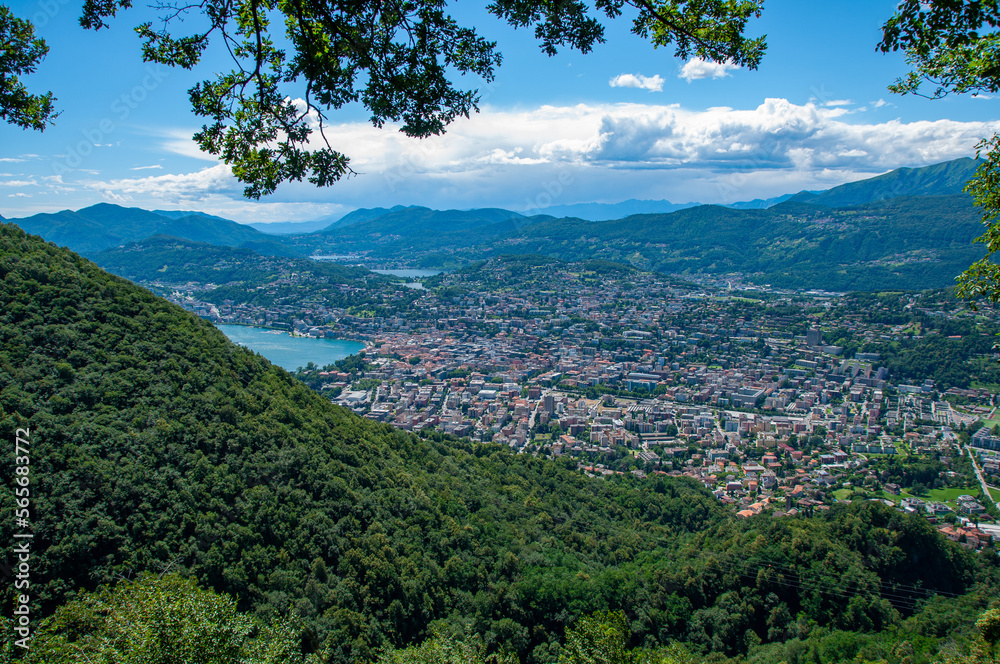 Lugano and it's lakes, a town in Switzerland is at the base of a mountain in a valley on a sunny summer day