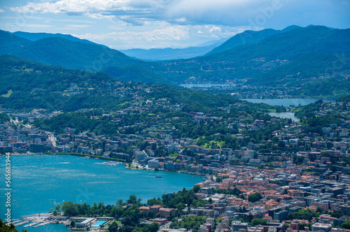 Lugano and its lakes, a town in Switzerland is at the base of a mountain in a valley on a sunny summer day