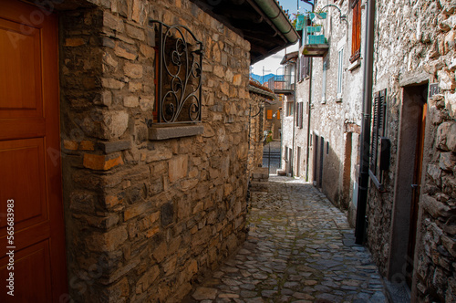 A cobblestone alleyway and stone residential houses on a sunny day in the mountains of Lugano Switzerland