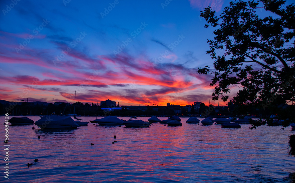 A beautiful sunset over Zurich Switzerland with boats parked on the lake