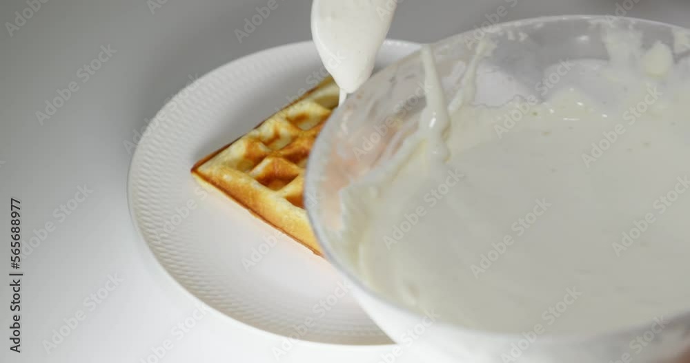 Sprinkling rectangular wafers with air cream when preparing dessert. Sprinkling rectangular wafers with air cream when preparing dessert.