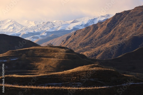Picturesque mountain landscapes of Dagestan - with ancient terraces and peach trees - and a blue sky with clouds on a sunny winter day.