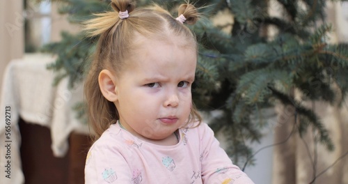 Wallpaper Mural Little cute girl looks at the camera with a funny frown and knitted eyebrows. The child grimaces at the camera with a funny frown. Portrait of cute baby face expression. Funny baby concept. Torontodigital.ca