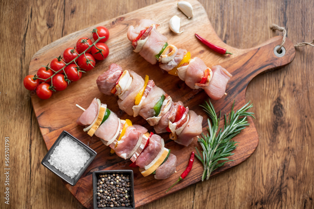 Raw meat skewers with vegetables on wooden background Raw meat skewers with vegetables on wooden background
