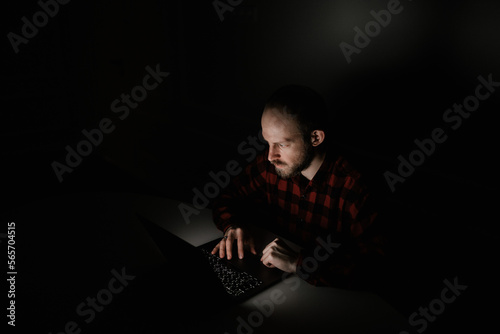 man with laptop in dark room