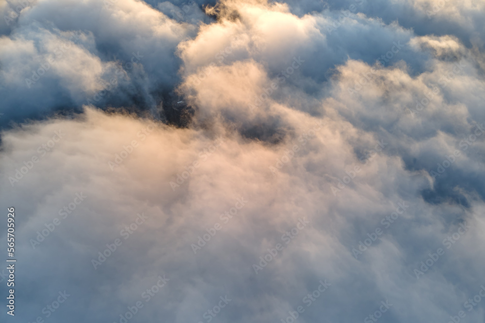 Aerial view from above at high altitude of dense puffy cumulus clouds flying in evening. Amazing sunset from airplane window point of view Aerial view from above at high altitude of dense puffy cumulus clouds flying in evening. Amazing sunset from airplane window point of view